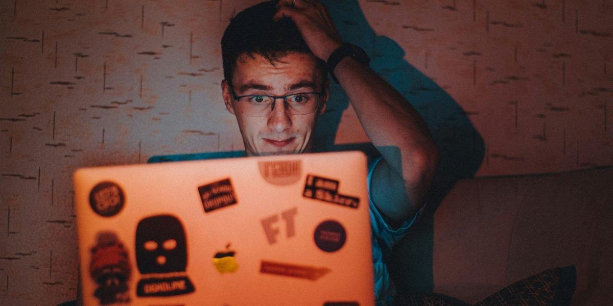 A person looking at a screen with a skeptical expression, symbolizing the crucial need to question and verify the authenticity of online visuals, especially deepfakes.