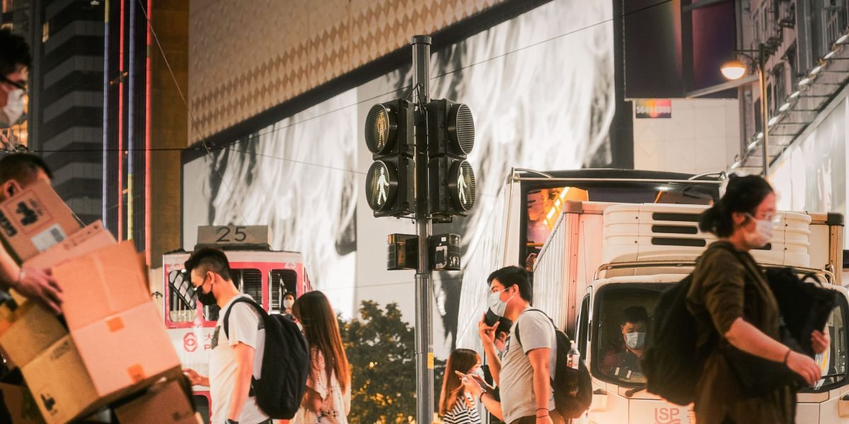 A person's face partially obscured within a bustling public city street, highlighting privacy concerns in visual surveillance.