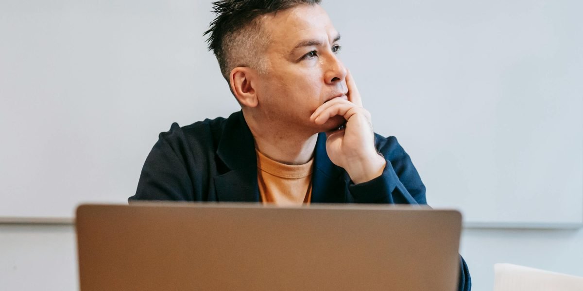 A person thoughtfully considering complex ethical dilemmas, symbolizing the application of ethical frameworks in design.