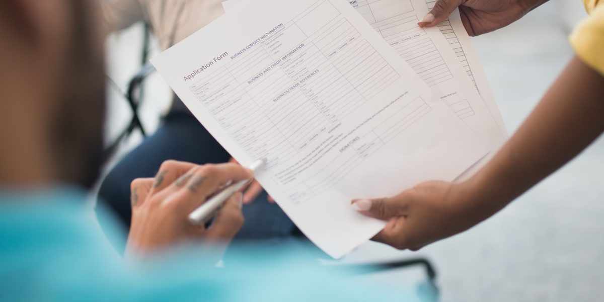 A team of professionals intently reviewing legal documents, symbolizing the complexity of regulatory compliance and precise language.
