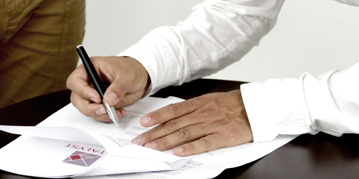 A person looking overwhelmed by a large volume of documents, symbolizing information overload.