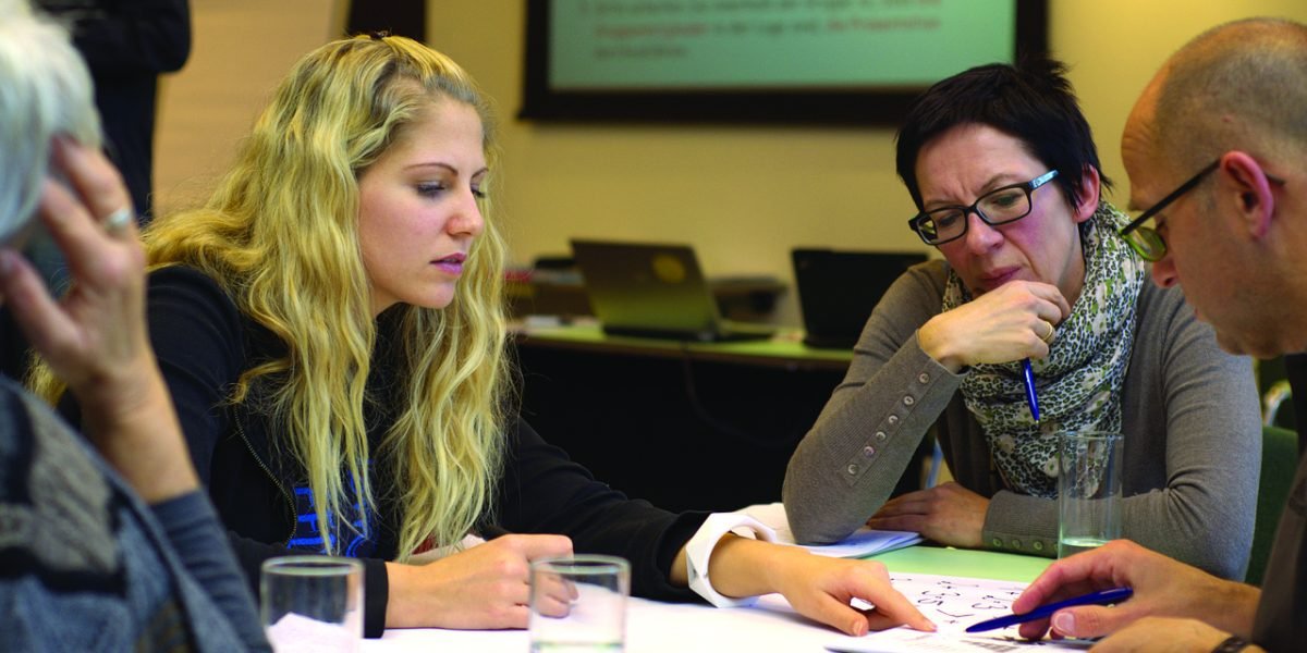 Professionals engaged in a deep discussion about the strategic implications of autonomous trucking technology.