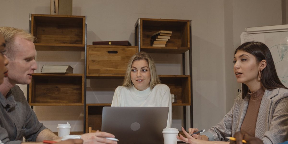 Professionals collaborate in a modern office, planning how AI's economic ripple effects will shape their industry.