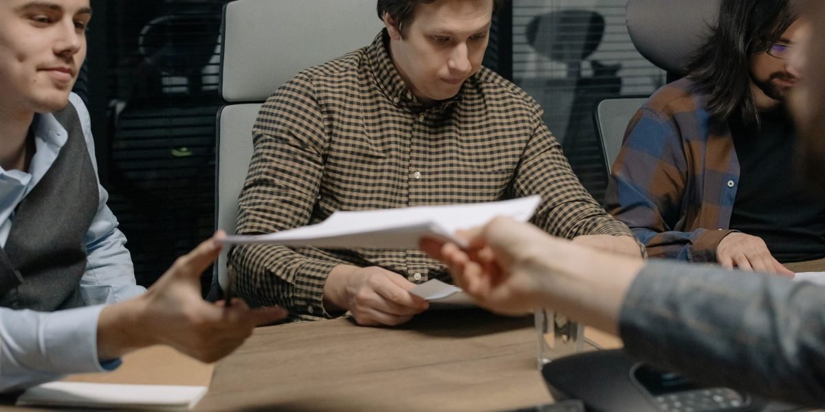 A team of professionals collaborating on documents, possibly discussing regulatory frameworks like the EU AI Act.