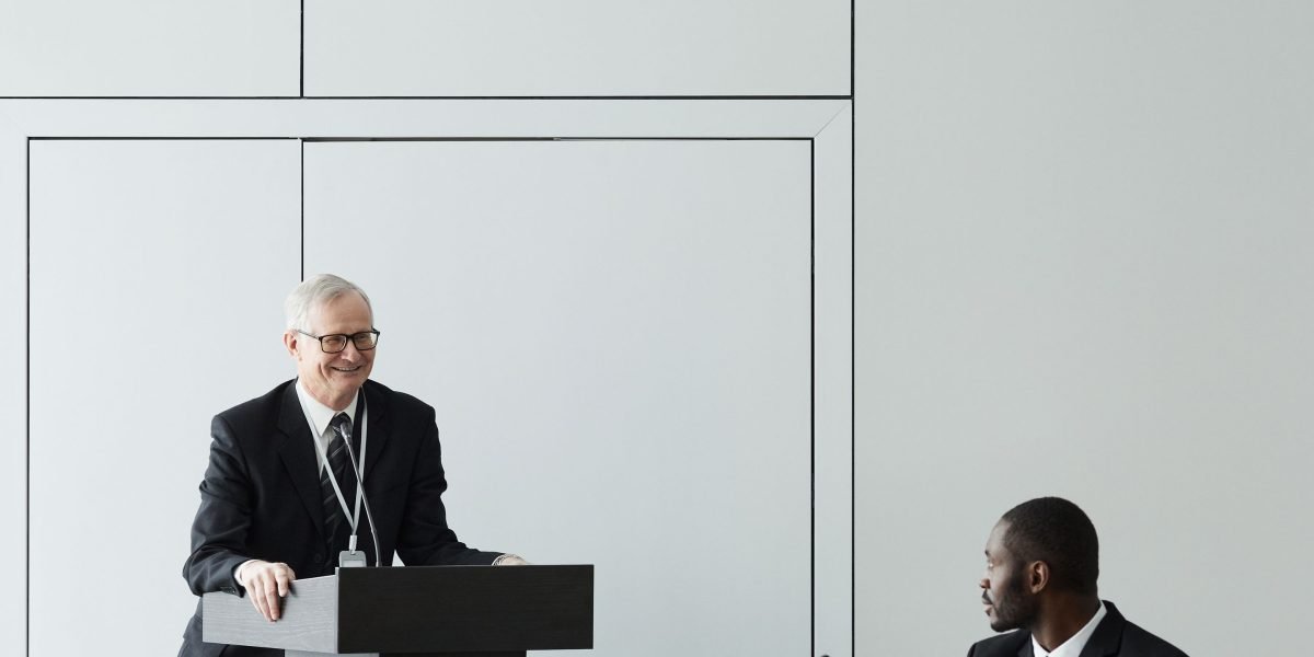 A founder confidently presenting their business plan and regulatory strategy to a group of investors, highlighting the new focus on policy risk.