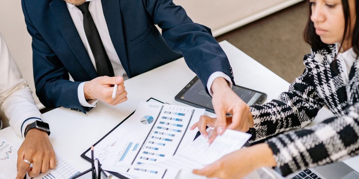 Two professionals discussing documents, highlighting the crucial human oversight and review processes needed for transparent and safe AI agent deployment.