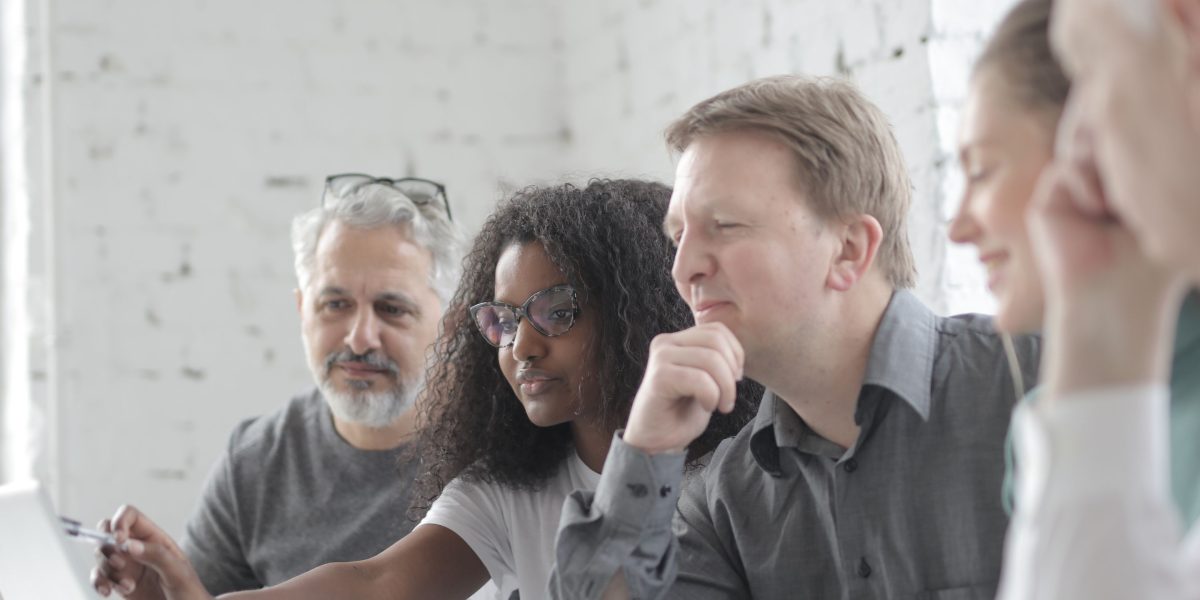 A diverse group of professionals collaborating and discussing the future implications of emerging AI technologies.
