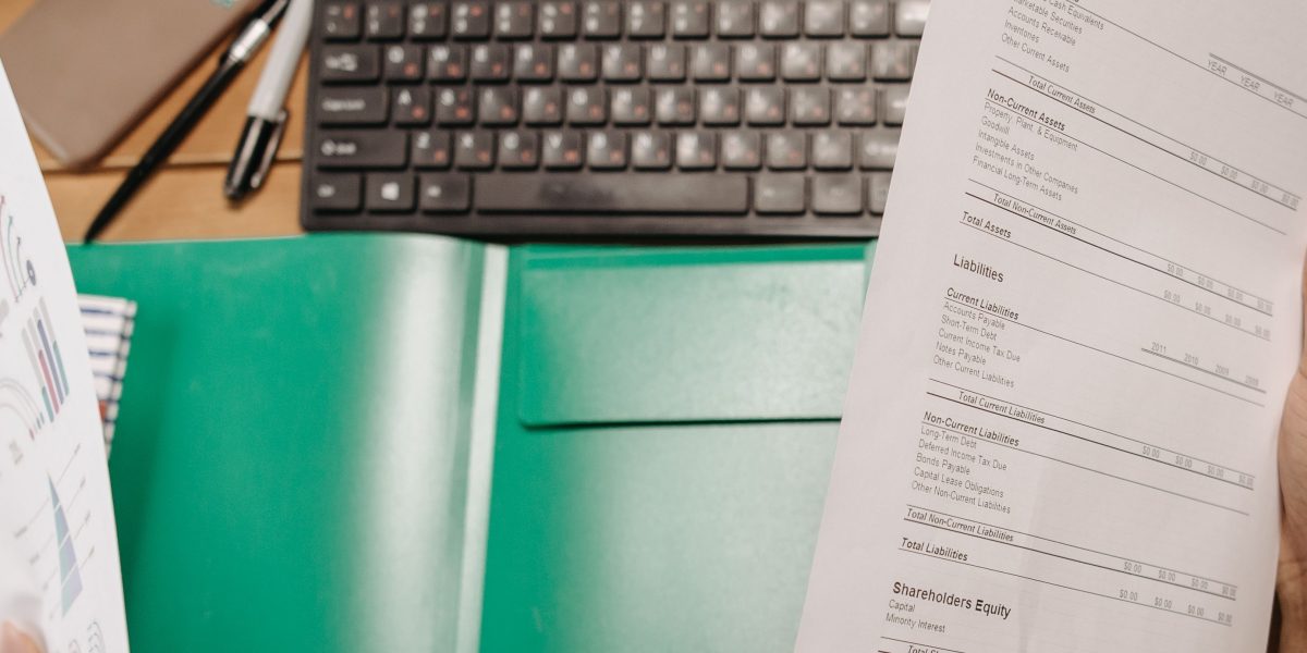 A person diligently managing and organizing essential business documents and filings in an office setting.
