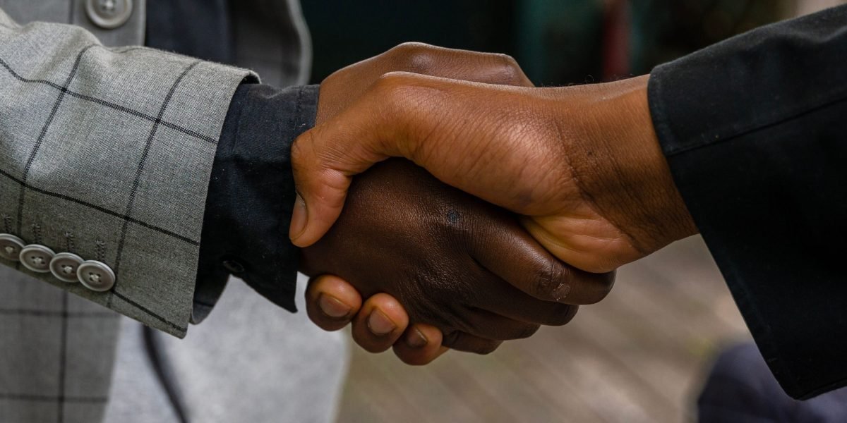 Professionals shaking hands, symbolizing the outcome of a policy negotiation or agreement.
