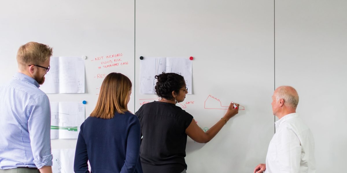 A group of professionals collaboratively organizing and categorizing information on a large whiteboard, reflecting the concept of taxonomies.