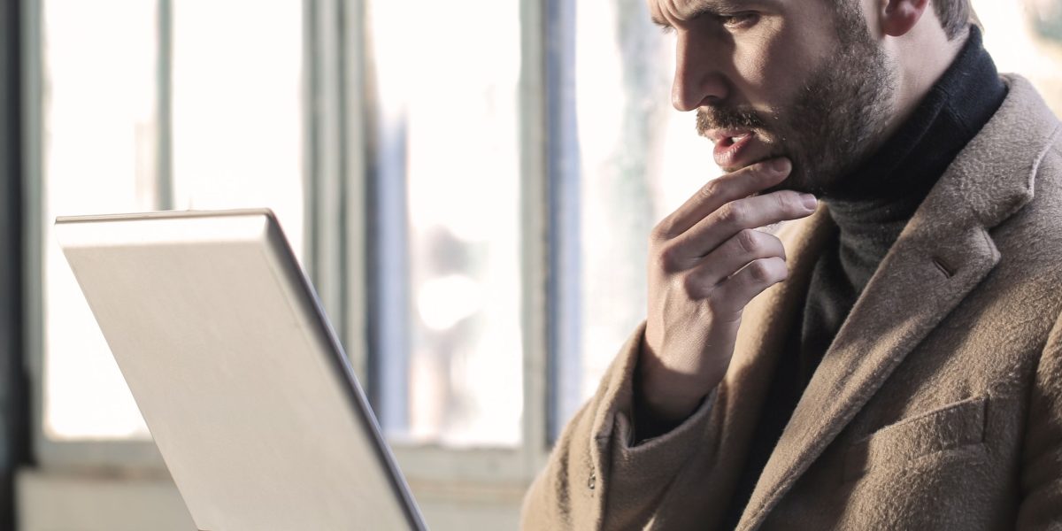 A person thoughtfully navigating complex information to make informed decisions in technology.