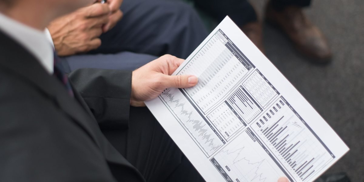 Business professionals analyzing performance reports and data to assess the return on AI investments.