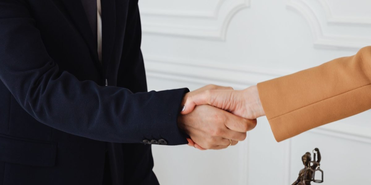 Two business professionals shaking hands, symbolizing a successful partnership or collaboration for scaling a small business.