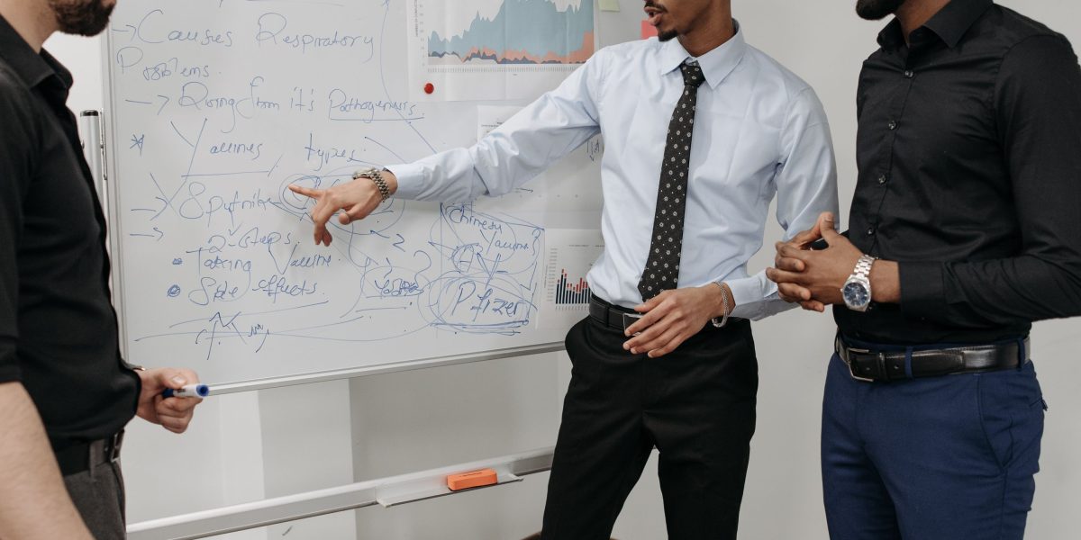 A team actively brainstorming and using a whiteboard to prioritize tasks, applying frameworks to focus on high-impact work.