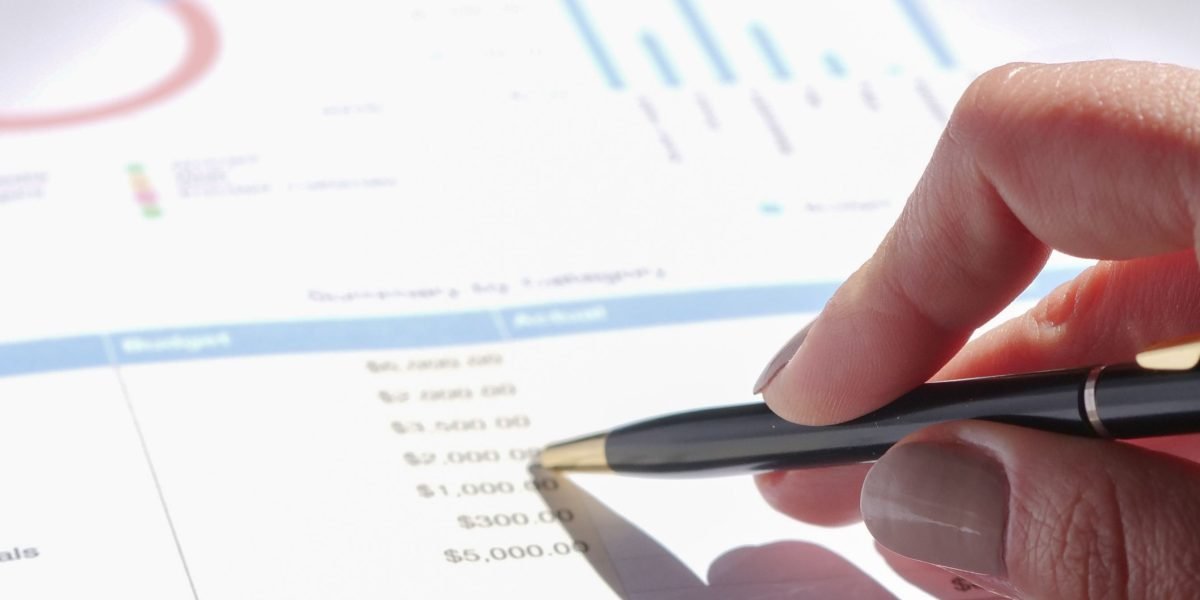 An individual carefully reviewing financial reports, assessing the profitability of a business idea.