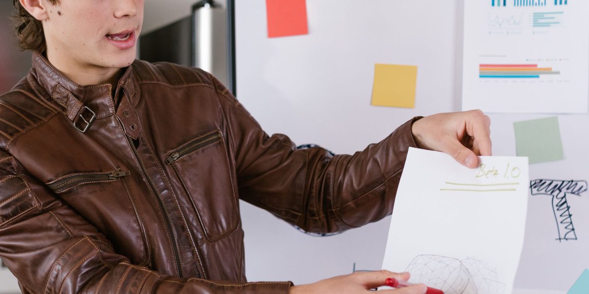 An individual thoughtfully organizing their initial business concepts and plans on a whiteboard.