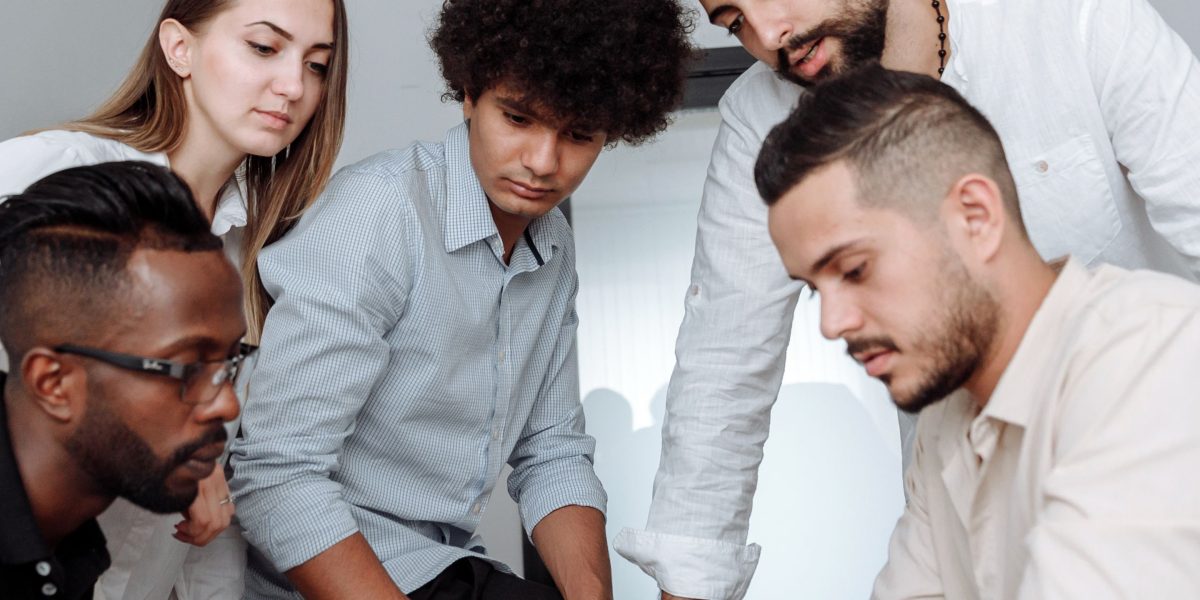 A team collaborates in an office, brainstorming solutions to a complex problem, reflecting the challenges of addressing ghost companies.